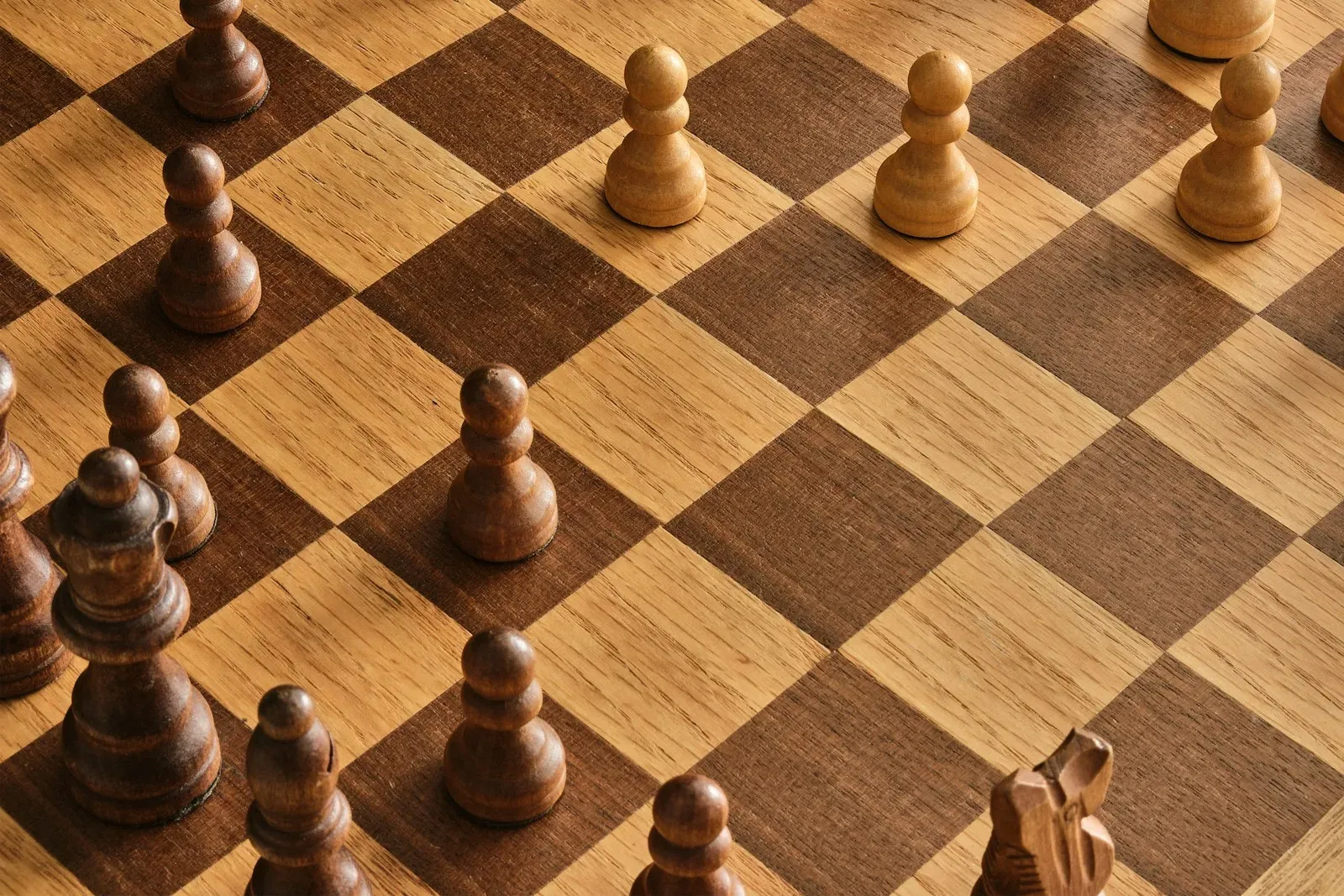 A wooden chessboard seen from above (photo by Jani Kaasinen on Unsplash)