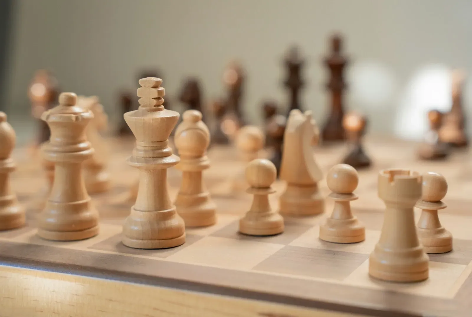 Chess pieces mid-game on a wooden board (photo by Heriberto Murrieta on Unsplash)