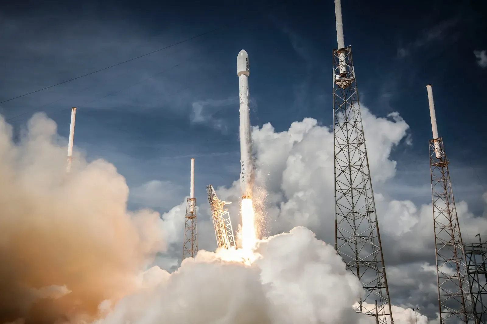 A Falcon 9 rocket lifting off in a cloud of smoke (photo by SpaceX on Unsplash)